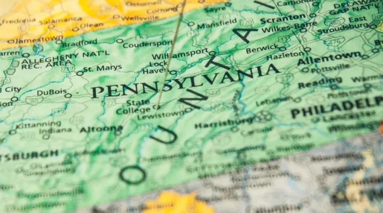 Close-up of a printed map highlighting Pennsylvania with surrounding states visible, including 'PENNSYLVANIA' prominently displayed.